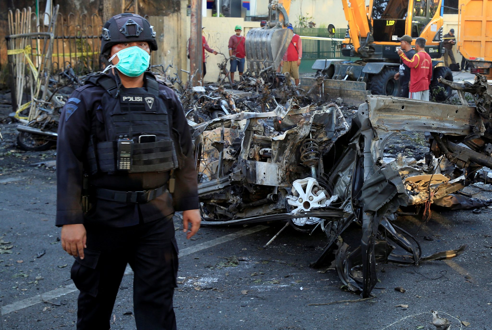 Indonesian Special Forces Police stands near the car wreck that crashed into the church in Surabaya | REUTERS